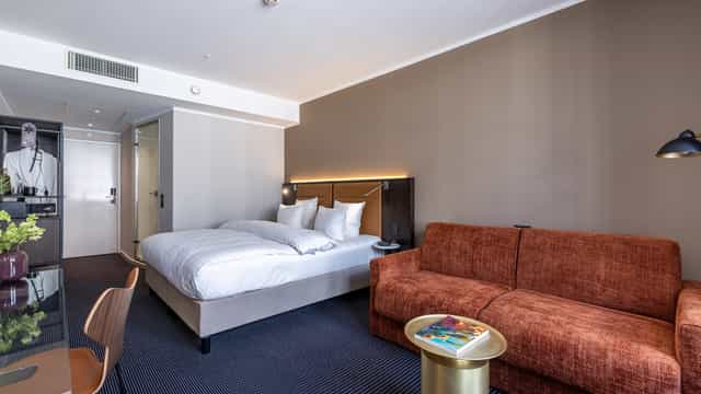 Modern hotel guest room with workspace for corporate travel and business accommodation.