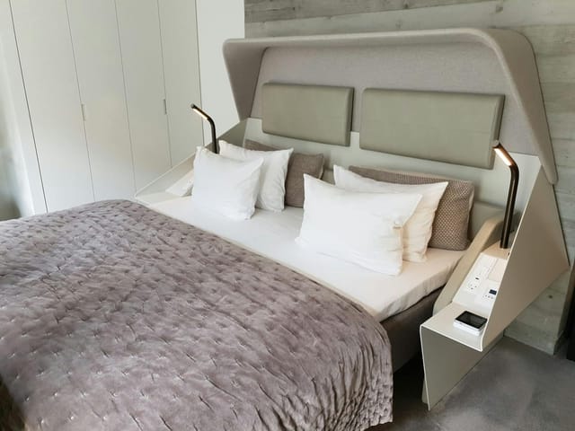 Modern hotel guest room with sleek multifunctional headboard for business travel and accommodation.