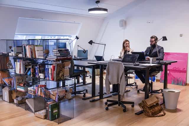 Modern coworking lounge in Østerbro with standing desks, ideal for corporate events and workshops.