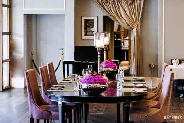 Upscale private wine room with purple florals and candles for VIP dinners or corporate meetings.