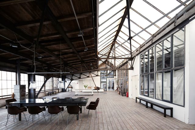 Industrial-chic loft with sawtooth glass ceiling for creative workshops and product launches.