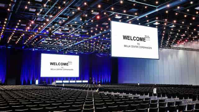 Bella Center plenary session with overhead lights for large corporate events and conferences.