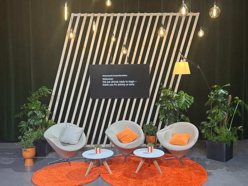 Stylish event setup with modern seating and geometric backdrop for workshops or panels.