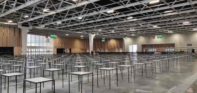 Viparis exhibit hall with high ceilings, set up for large-scale corporate conference and exam event.