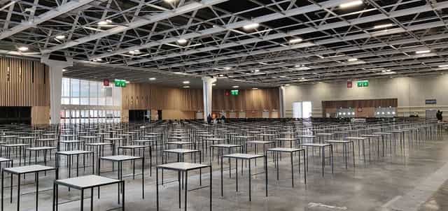Viparis exhibit hall with high ceilings, set up for large-scale corporate conference and exam event.