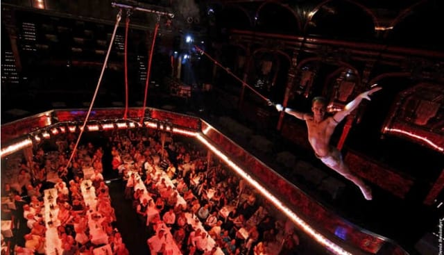 Aerial performers at a Paradis Latin gala dinner in a historic theater for corporate events.