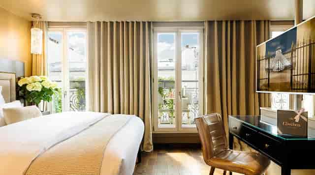 Upscale hotel room with Parisian balcony for executive retreats and VIP events.