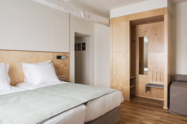 Modern hotel room with minimalist decor, ideal for business travel and corporate event planning.