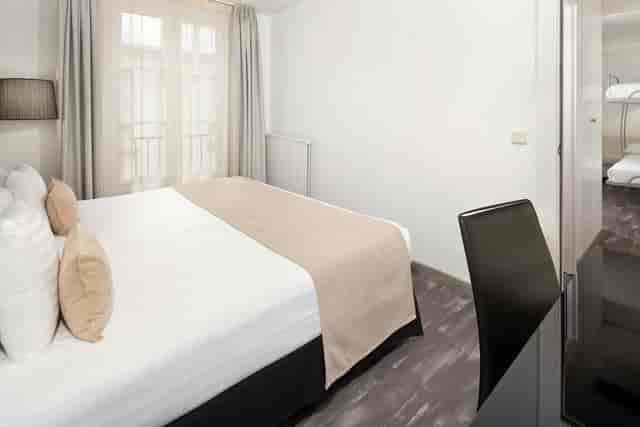 Compact hotel room at Montmartre Paris Opera with bunk beds for group travel and event lodging.