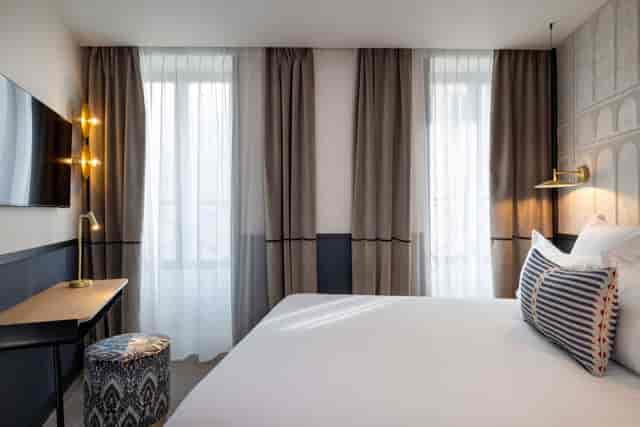 Modern hotel room with functional workspace for corporate business travel and boutique conferences.