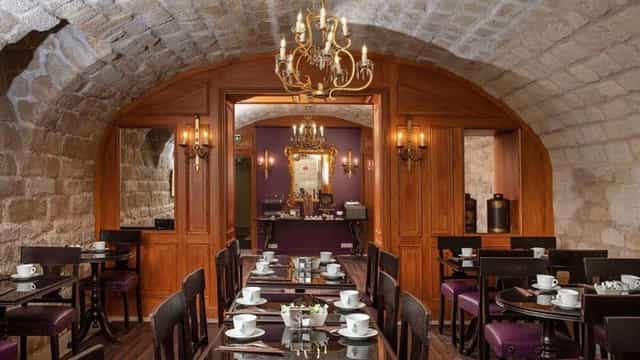 Vaulted guest lounge at Hôtel L de Lutèce, ideal for corporate dinners and private board meetings.