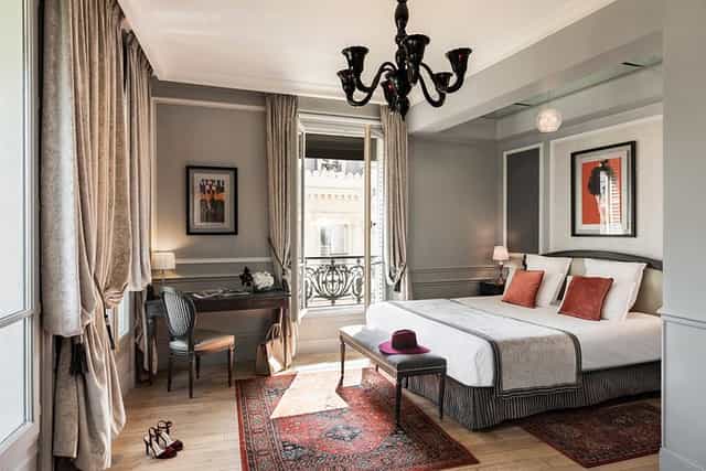 Upscale Parisian boutique hotel room with balcony for VIP stays and executive retreats.
