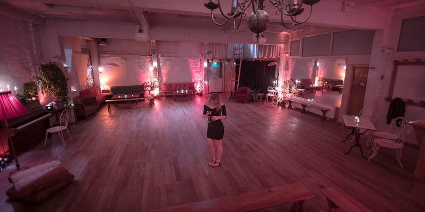 Industrial-chic loft function room with pink uplighting for cocktail receptions and mixers.
