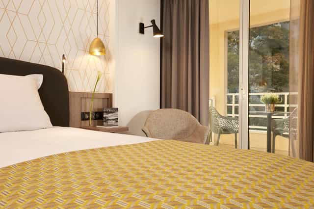 Modern hotel suite with balcony for conference lodging and business travel accommodation.