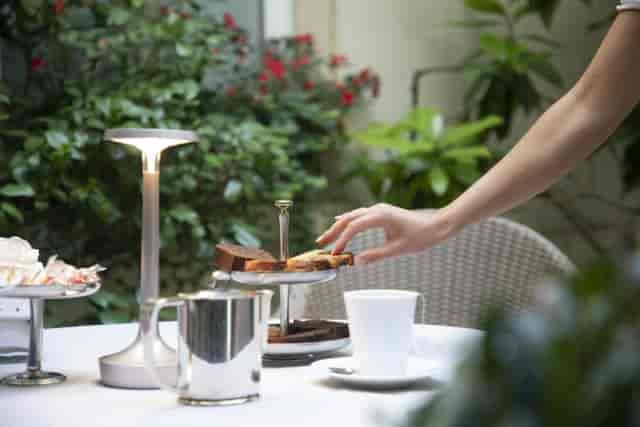 Intimate garden terrace coffee break setup for upscale networking event.