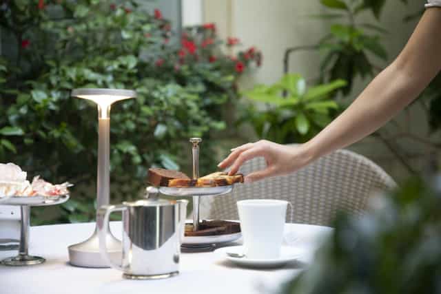 Intimate garden terrace coffee break setup for upscale networking event.