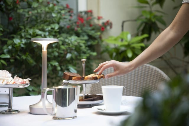 Intimate garden terrace coffee break setup for upscale networking event.