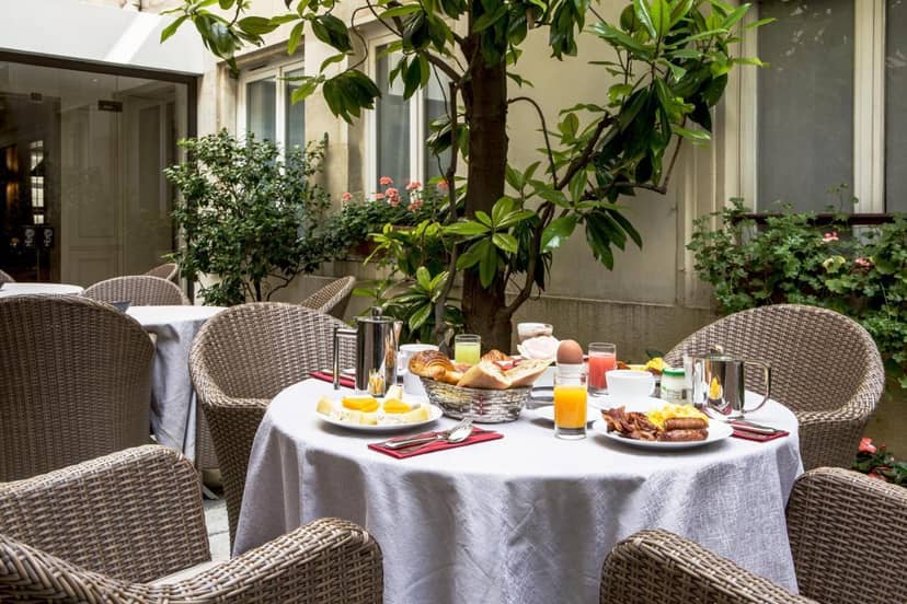 VIP breakfast setup in a secluded courtyard, Hôtel des Saints Pères boutique networking event.