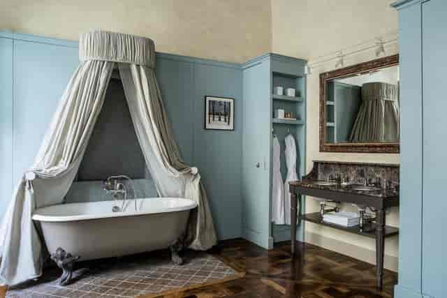 Luxury suite with dramatic curtained bathtub for VIP events and incentive travel.