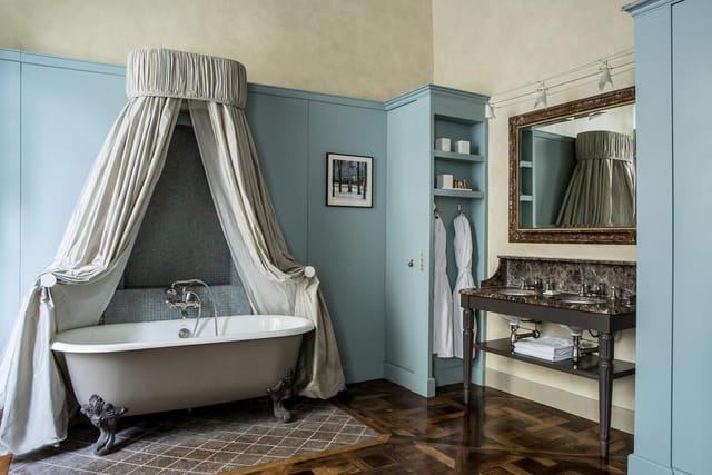 Luxury suite with dramatic curtained bathtub for VIP events and incentive travel.