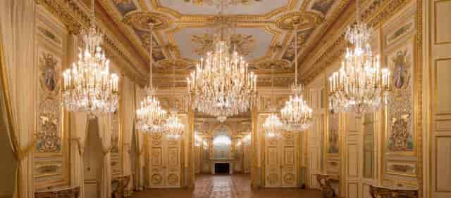 Opulent Cour d’honneur ballroom with crystal chandeliers for luxury galas and corporate events.