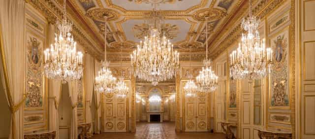Opulent Cour d’honneur ballroom with crystal chandeliers for luxury galas and corporate events.