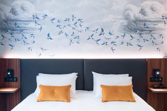 Le Salon Caché modern hotel room with integrated tech for corporate travel and business meetings.