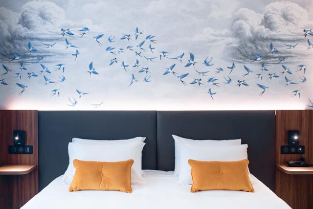 Le Salon Caché modern hotel room with integrated tech for corporate travel and business meetings.
