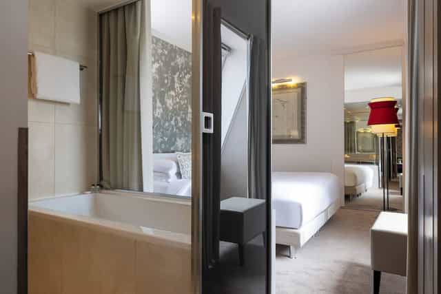 Modern hotel room with open bathroom at Hôtel Étoile Maillot for VIP executive travel.