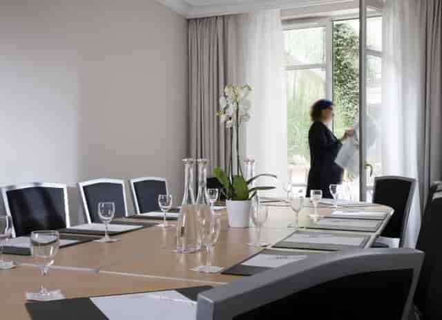 Boardroom setup at Hôtel Le Littré with floral decor for professional business meetings.