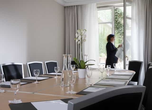 Boardroom setup at Hôtel Le Littré with floral decor for professional business meetings.