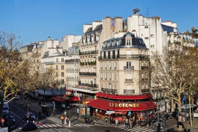 Hôtel Raspail Montparnasse suite overlooking a classic Parisian street corner for networking events.
