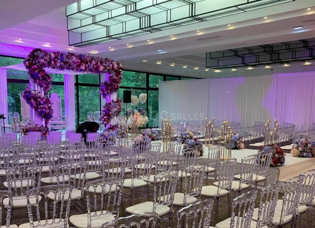 Modern wedding ballroom at Le Salon Toffoli with floral arch and ghost chairs for event hire.