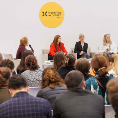 B2B panel discussion at Franchise Expo Paris with branded workshop seating.