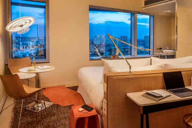 Modern bleisure hotel room in Paris with workstation and city view for business travel.