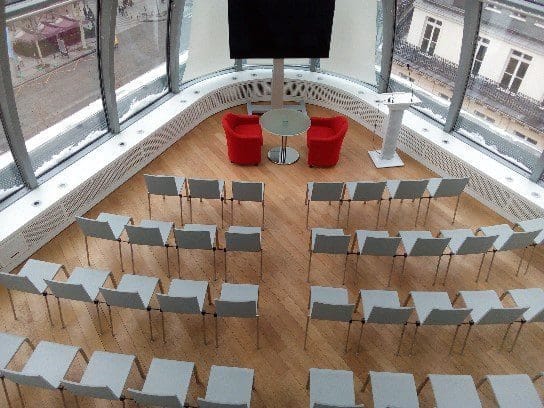Modern curved theater breakout room at Rooftop Elysées for panel discussions and fireside chats.