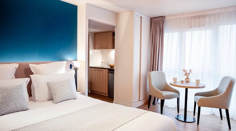 Residhome Saint-Ouen suite: modern business hotel room with meeting space for corporate travel.