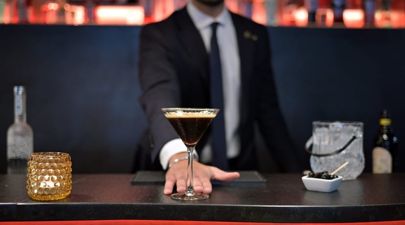 Bartender serving espresso martini at The One Alma Paris evening reception.