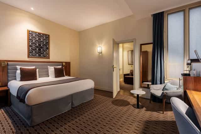Hotel room with workspace at Mayflower Suites, ideal for corporate travel and business meetings.