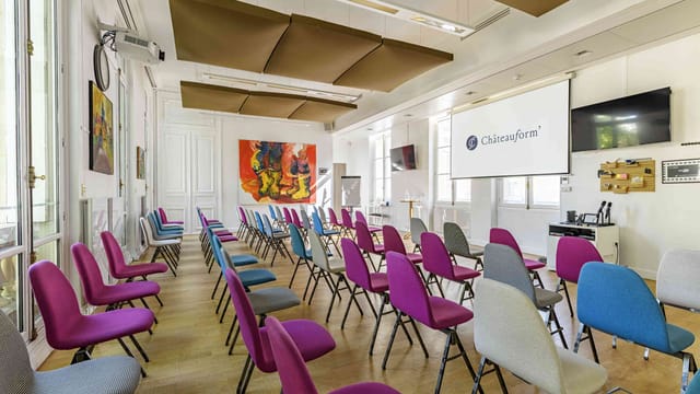 Modern theater-style meeting room with vibrant seating for creative workshops and conferences.