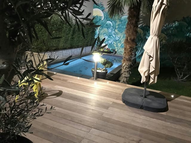 Lush poolside patio with tropical mural for boutique evening receptions and corporate events.