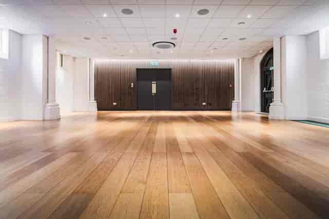 Community Hall: minimalist event space with wood floors for corporate workshops or receptions.