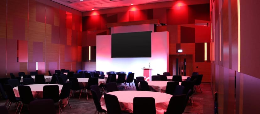 Formal event space in ICC Birmingham with circular tables for conferences and seminars.