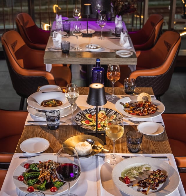 Ommia venue for executive dining and corporate networking events with modern table lighting.