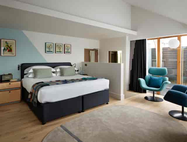 Modern hotel room with cozy bed, ideal for meetings and retreats at Marrable's Hotel.