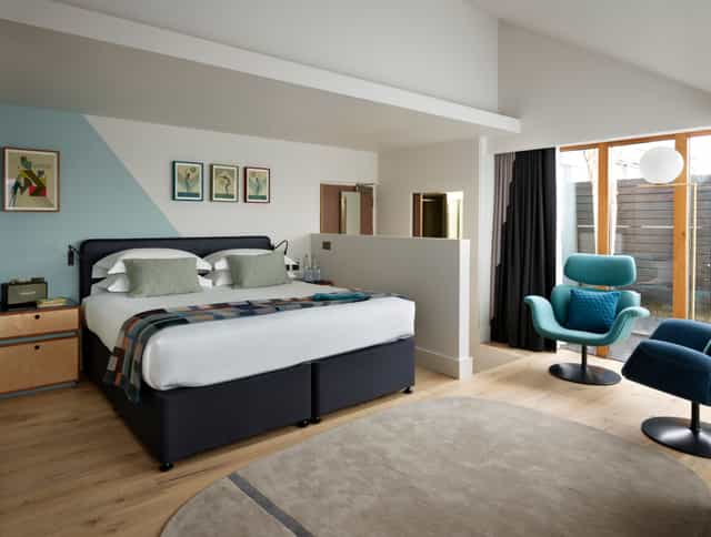 Modern hotel room with cozy bed, ideal for meetings and retreats at Marrable's Hotel.