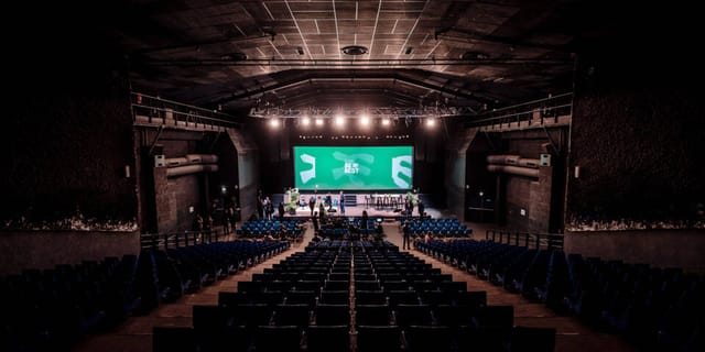 Transbordeur concert hall with stage, AV trussing, and large screen for keynote or general session.