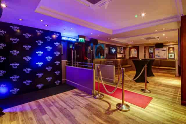 Stylish networking event at Hard Rock Cafe London with red carpet and ambient lighting.
