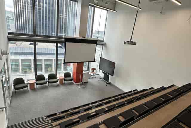 Modern tiered auditorium at XCHG with stage and AV for executive briefings and presentations.