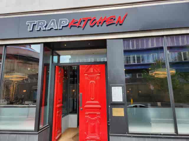 Red door entrance of Trap Kitchen restaurant, ideal for edgy brand activations and intimate events.